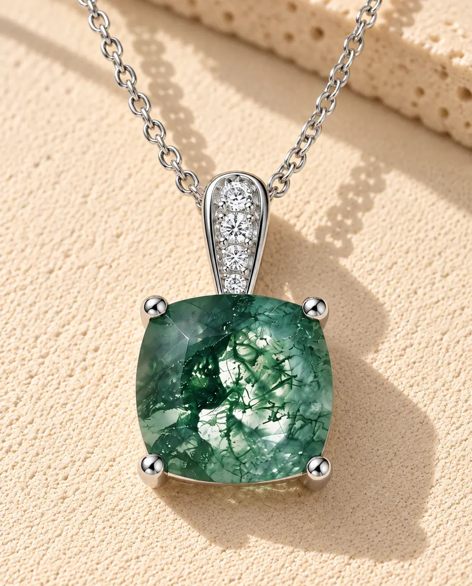 Collar Solitario de Ágata Musgosa en Plata 925 - sobre una superficie clara con textura junto a un bloque de travertino