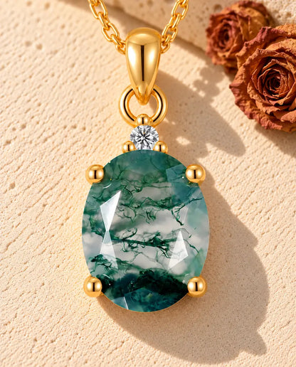 Collar Solitario de Ágata Musgosa Ovalada en Plata 925 Chapada en Oro - sobre una superficie clara con textura junto a un bloque de travertino