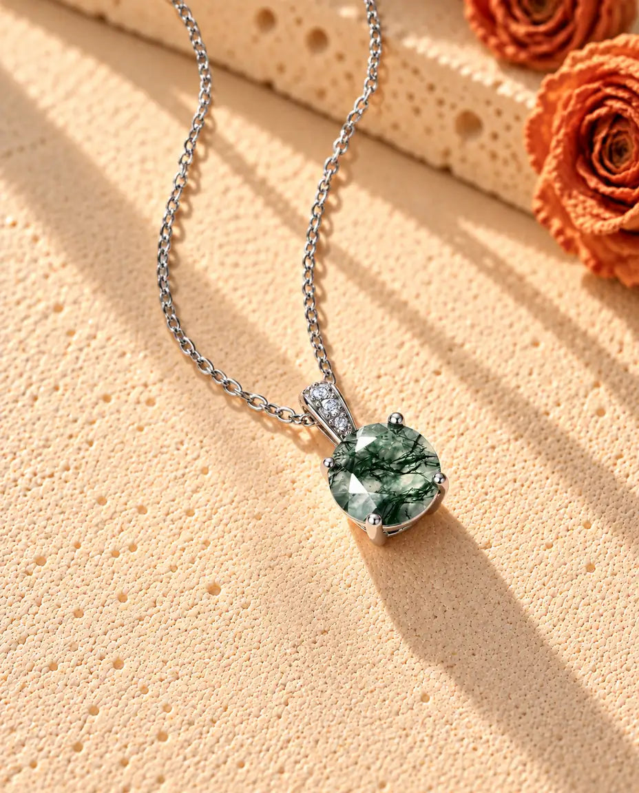 Collar Solitario de Ágata Musgosa Redonda en Plata 925 - visto en ángulo sobre una superficie clara con textura