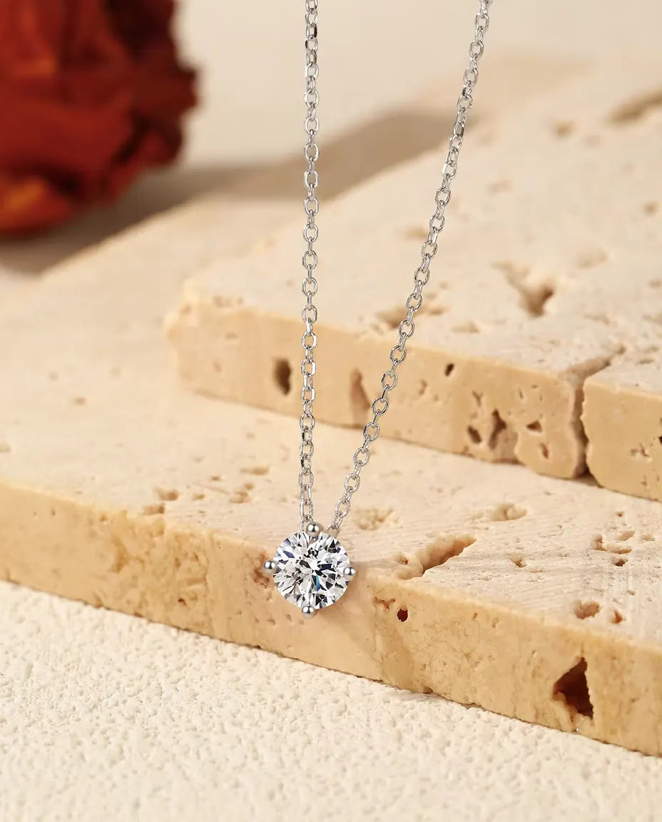 Collar Solitario de Moissanita 1 ct en Plata 925 - colgante sobre el borde de una losa de travertino