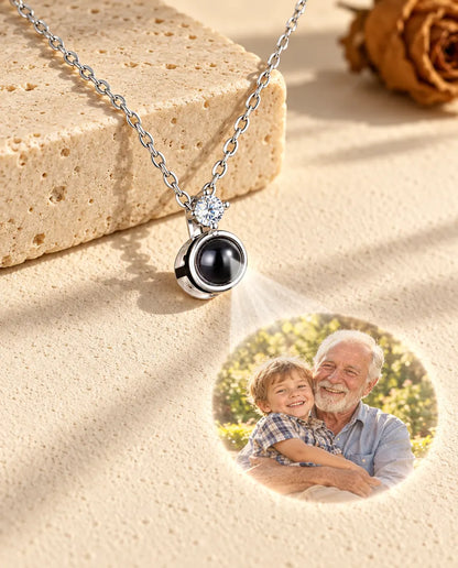 Collar solitario plateado que proyecta la foto de un abuelo con su nieto sobre yeso