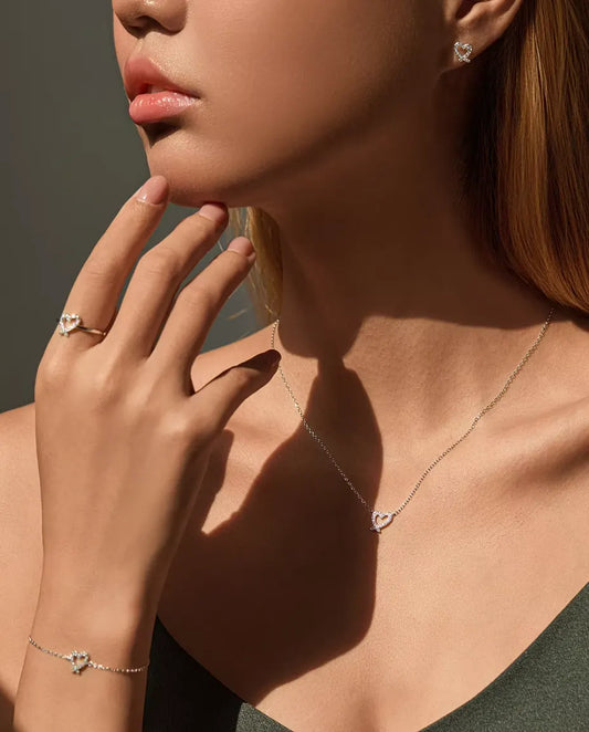 Modelo con el conjunto completo de corazón de moissanita: collar, pulsera, anillo y pendientes