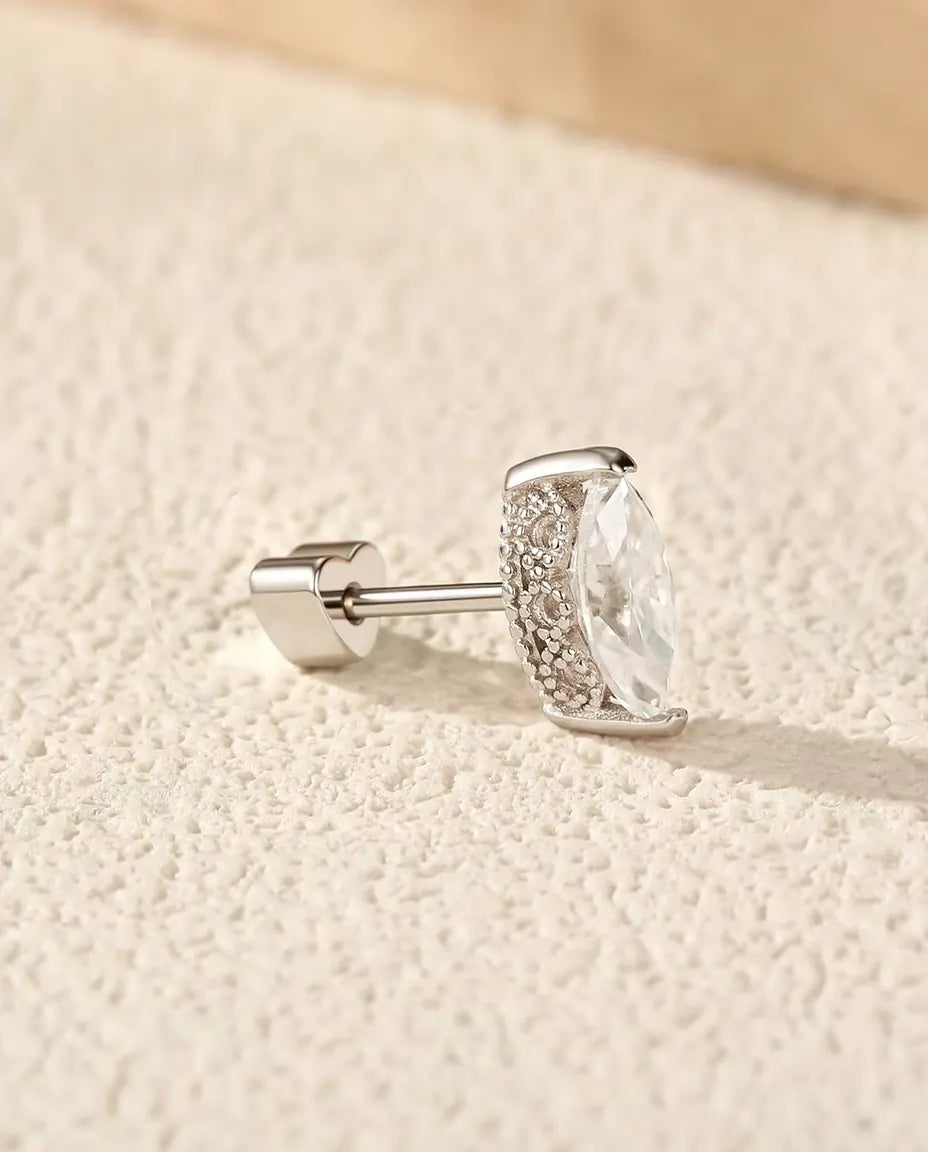 Pendientes de Moissanita Marquesa en Plata 925 - sobre una superficie clara con textura junto a una losa de travertino