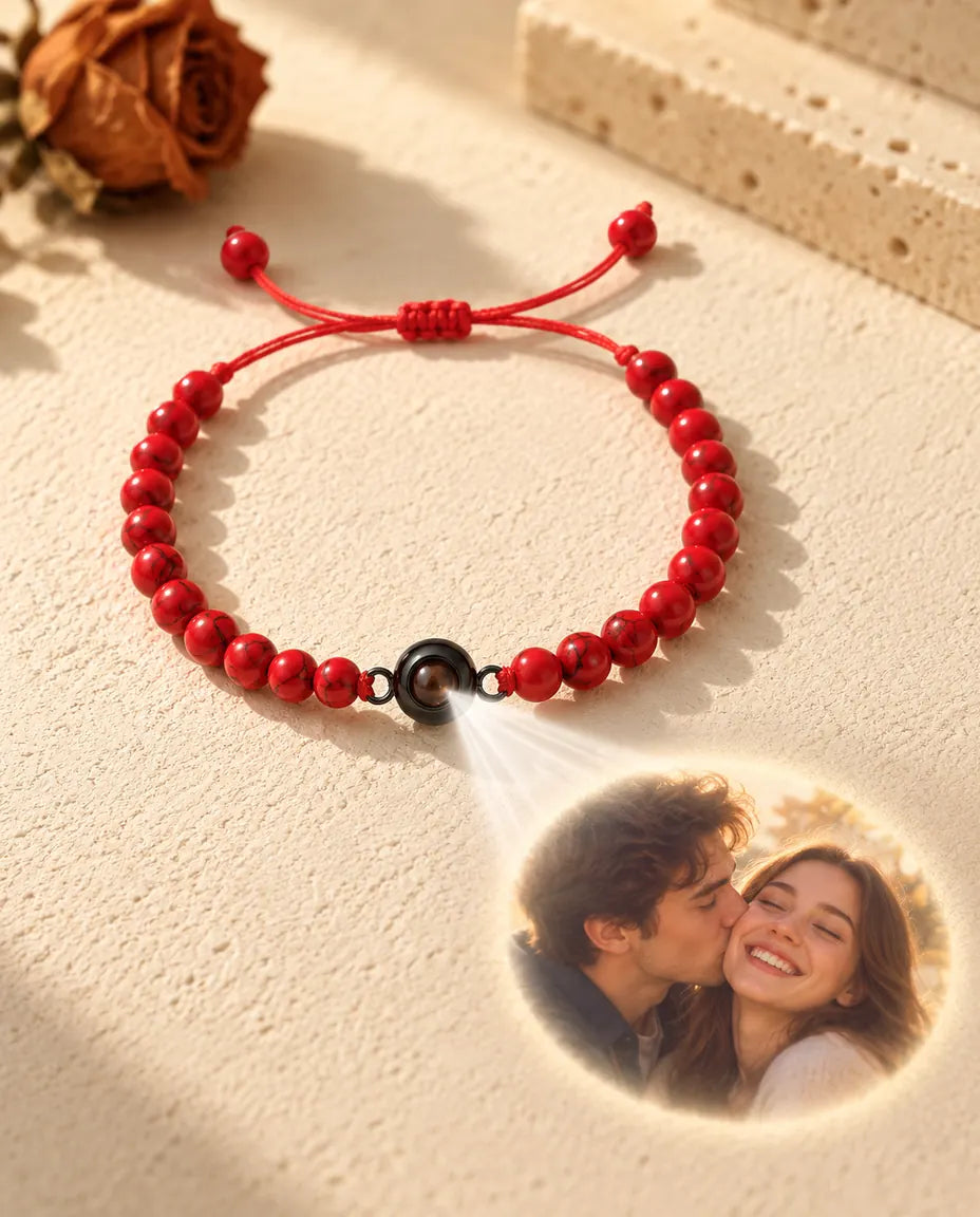 La luz atraviesa la piedra marrón de la pulsera de bolas rojas y proyecta la foto de una pareja sonriente