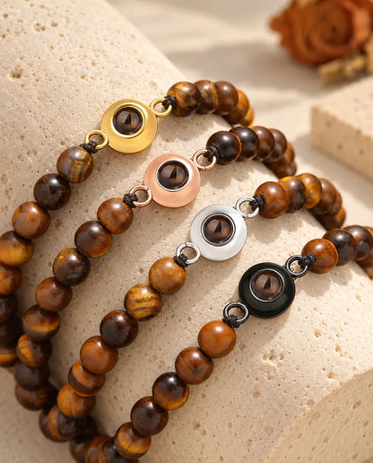 Pulseras de bolas de ojo de tigre con los cuatro colores de aro sobre un bloque de travertino