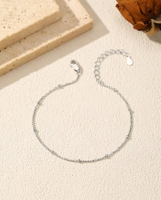 Pulsera de Bolitas en Plata 925 - extendida sobre una superficie clara con textura, con cierre y alargador