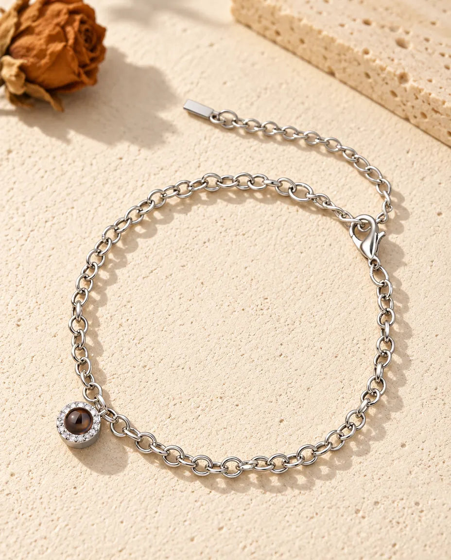 Pulsera con foto dentro personalizada, plateada, con mini colgante redondo de circonitas en cadena fina, sobre yeso