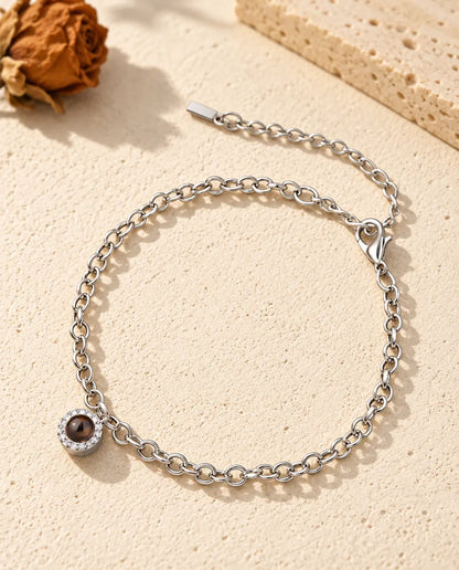 Pulsera con foto dentro personalizada, plateada, con mini colgante redondo de circonitas en cadena fina, sobre yeso