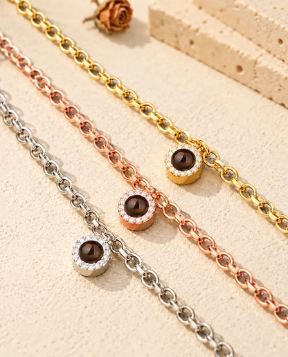 Primer plano de tres pulseras de circonitas con foto dentro en dorado, color oro rosa y plateado