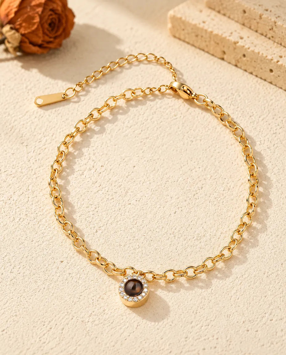 Vista cenital de la pulsera dorada con colgante de circonitas y su cadena de extensión