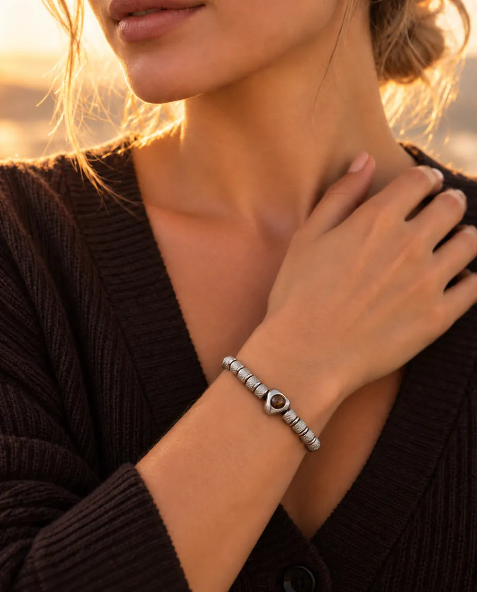 Mujer con la mano en la clavícula y la pulsera plateada de cuentas con corazón y foto dentro