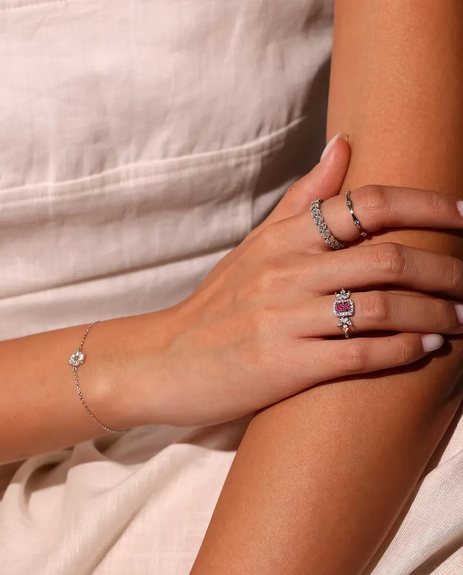 Pulsera Flor de Moissanita en Plata 925 - llevada en la muñeca, con las manos cruzadas sobre el pecho