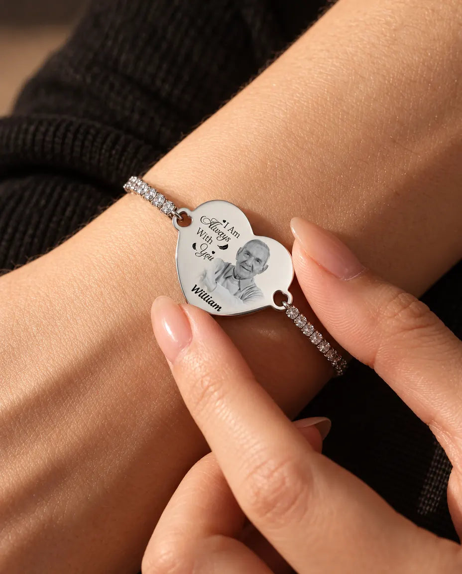 Yemas de los dedos sujetando el corazón grabado con foto de la pulsera tennis plateada