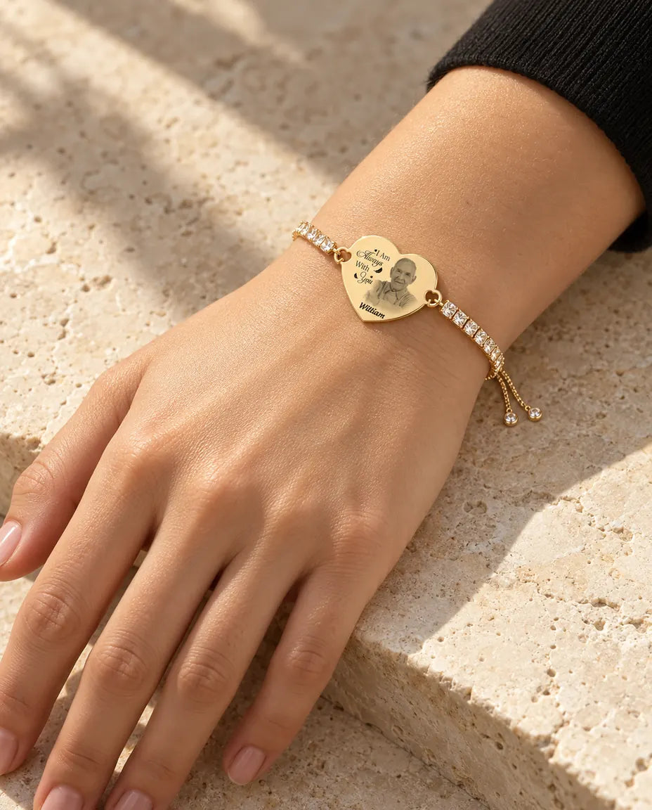 Mujer que lleva la pulsera dorada con corazón grabado con foto
