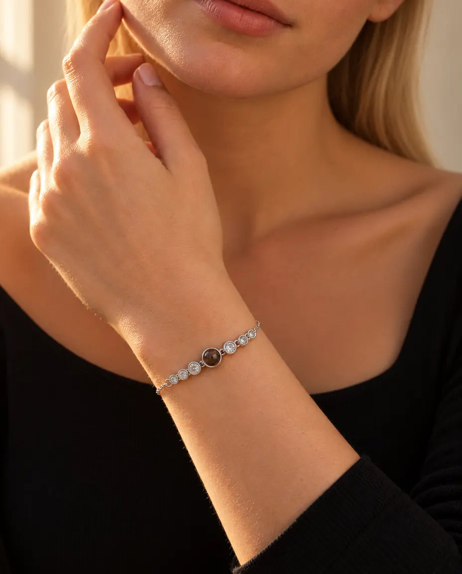 Mujer que se toca la mandíbula con la pulsera plateada de fila de circonitas y foto dentro
