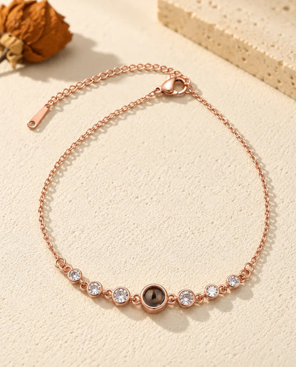 Pulsera con foto dentro color oro rosa con seis circonitas en bisel, cierre de mosquetón y cadena de extensión