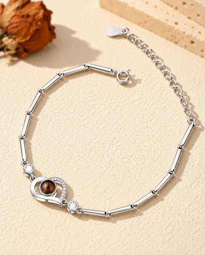 Pulsera con foto dentro personalizada en plateado con corazón abierto en cadena de barritas, sobre yeso crema