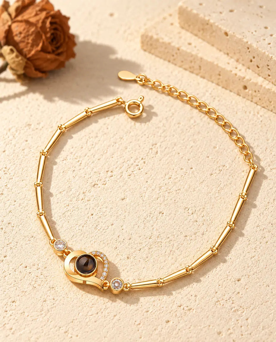 Pulsera dorada de corazón abierto con línea de circonitas, piedras laterales y cierre de reasa