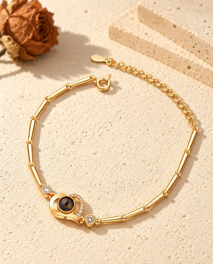 Pulsera dorada de corazón abierto con línea de circonitas, piedras laterales y cierre de reasa