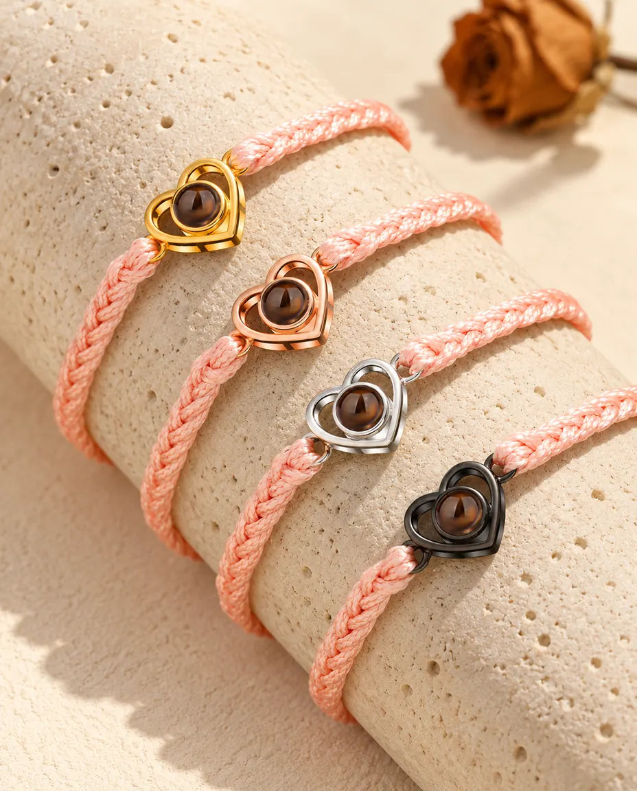 Pulseras de cordón trenzado rosa con el corazón abierto en todos sus colores, sobre travertino