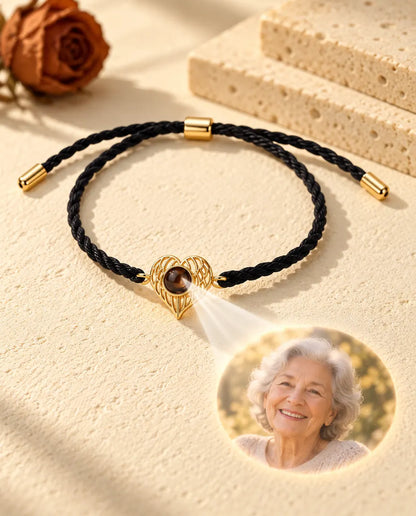 La luz atraviesa la piedra marrón del corazón dorado con alas y proyecta la foto redonda de una abuela sonriente