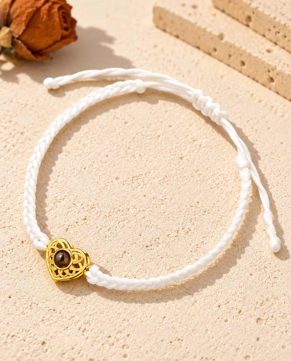 Pulsera con foto dentro de cordón trenzado fino blanco, con corazón dorado y cierre de nudo corredizo