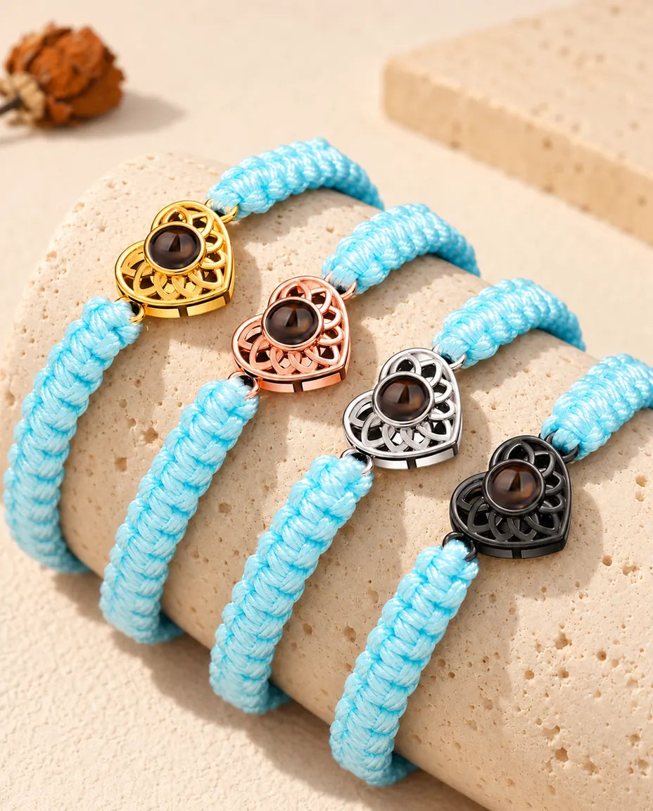 Pulseras de cordón trenzado azul claro en fila sobre un bloque de travertino, una por cada color de corazón