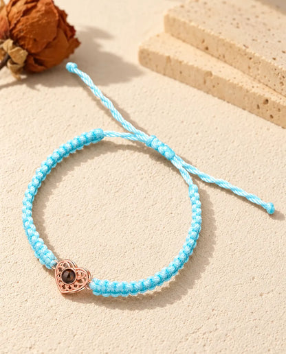 Corazón color oro rosa en un cordón trenzado azul claro con nudo corredizo ajustable