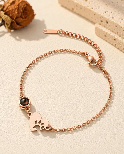 Pulsera de corazón con huella color oro rosa, con piedra redonda de proyección y cierre de mosquetón