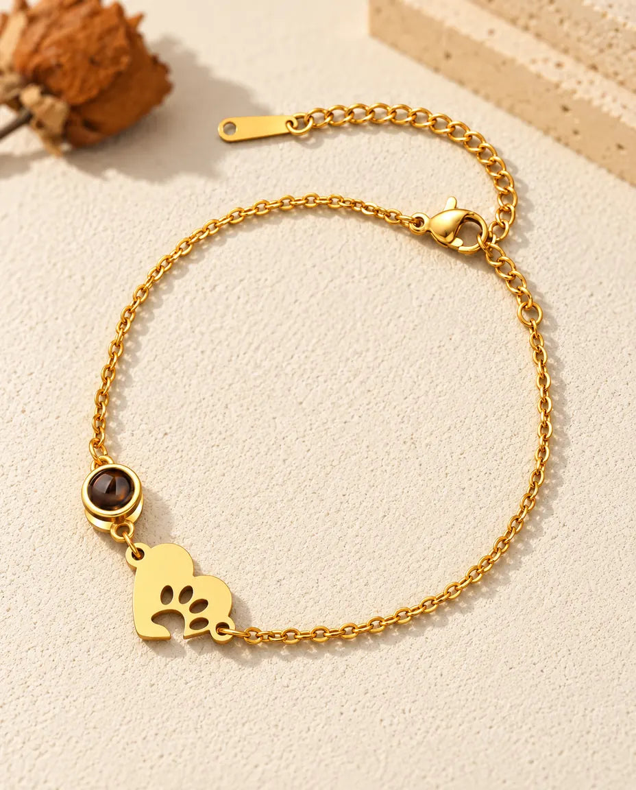 Pulsera recuerdo de mascota en dorado, con placa de corazón con huella de pata y cadena de extensión