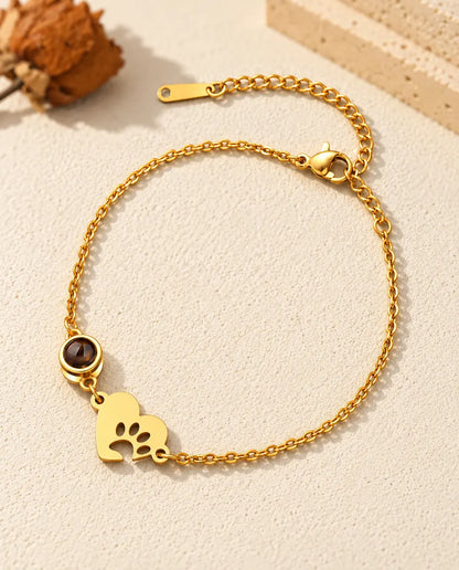 Pulsera recuerdo de mascota en dorado, con placa de corazón con huella de pata y cadena de extensión