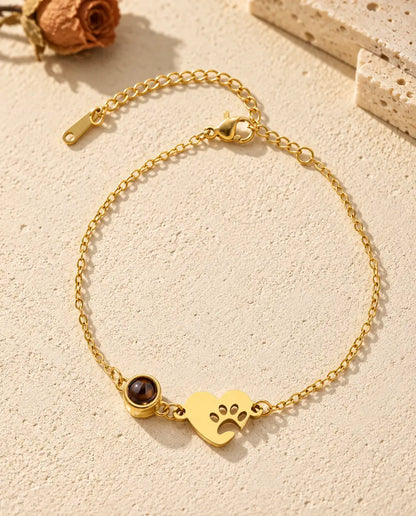 Vista cenital de la pulsera con foto dentro de corazón dorado con huella de pata