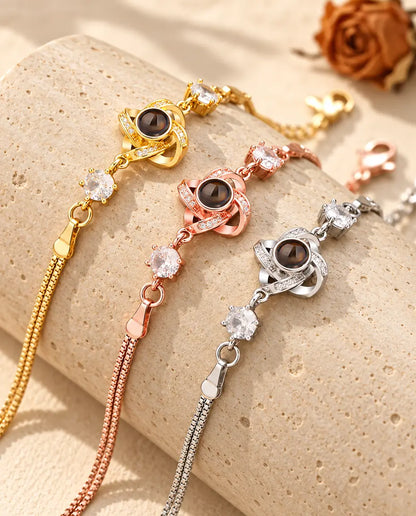 Tres pulseras de nudo de amor en dorado, color oro rosa y plateado sobre un bloque de travertino