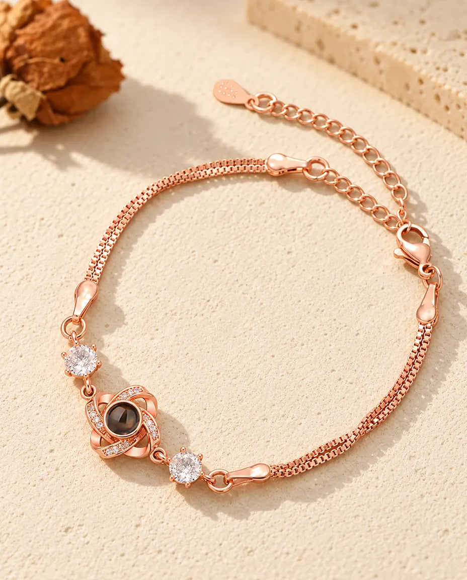 Pulsera de nudo de amor color oro rosa con circonitas brillantes a los lados y doble cadena veneciana