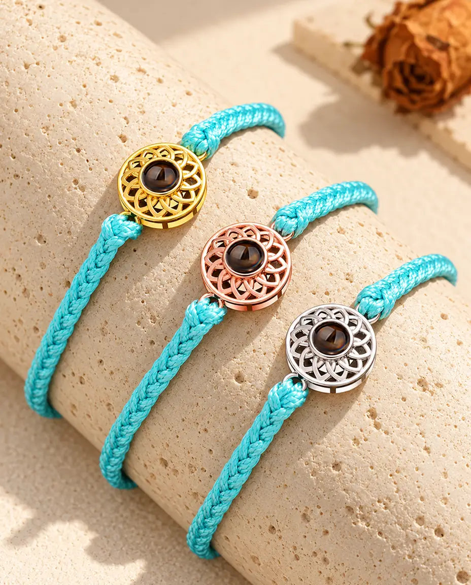 Pulseras de cordón trenzado fino azul con círculo dorado, color oro rosa y plateado sobre travertino