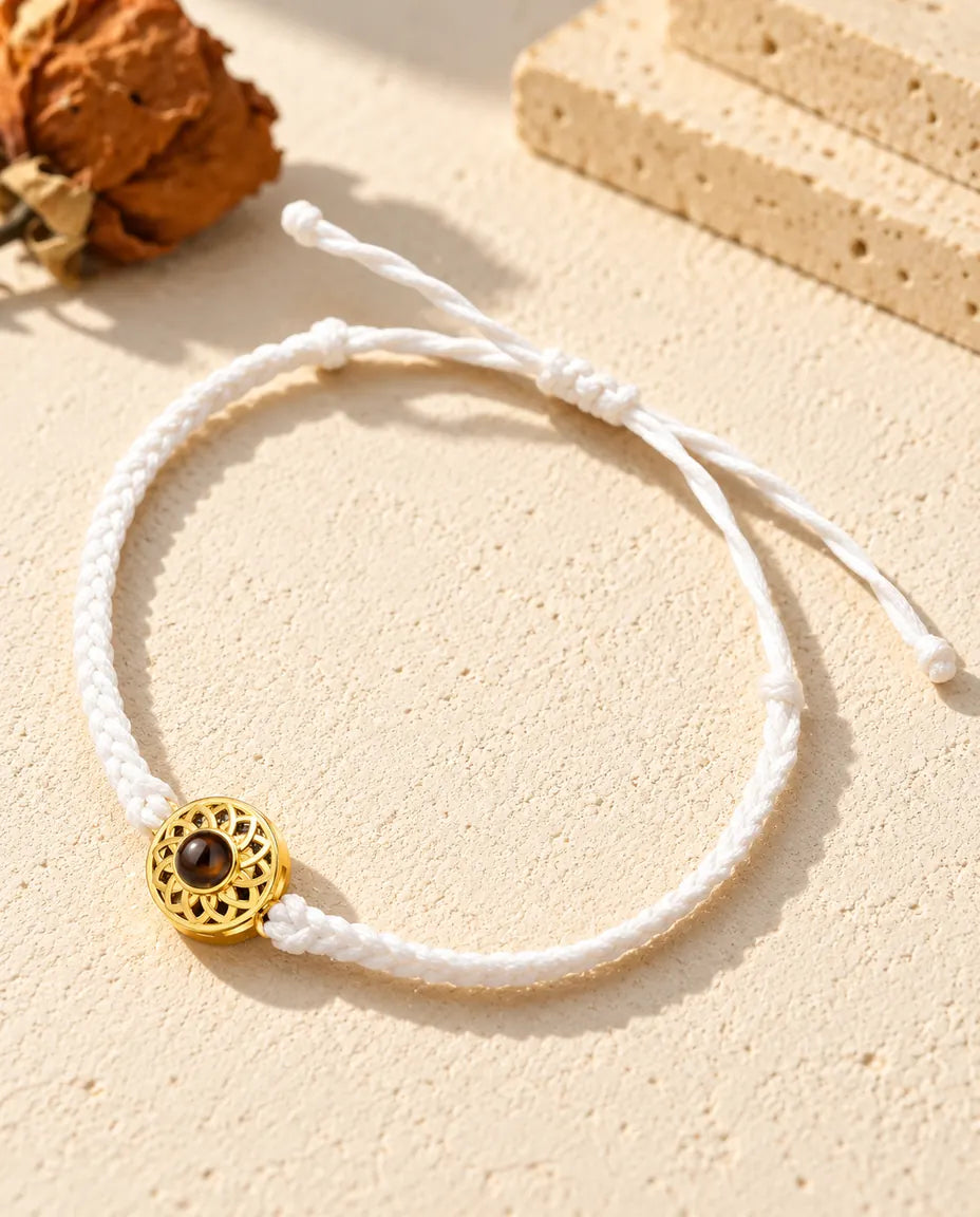 Pulsera con foto dentro de cordón trenzado fino blanco, con círculo dorado y cierre de nudo corredizo