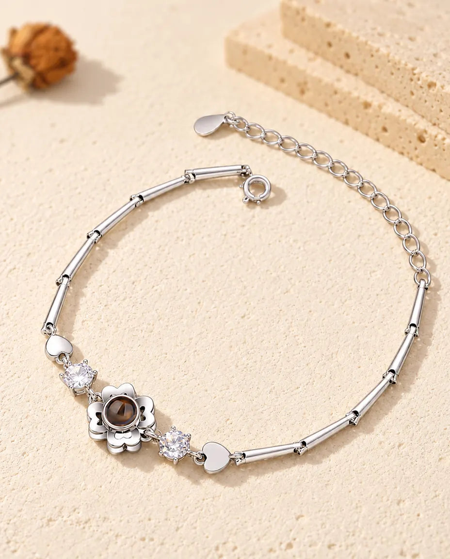 Pulsera con foto dentro personalizada en plateado con flor de trébol en cadena de barritas, sobre yeso crema