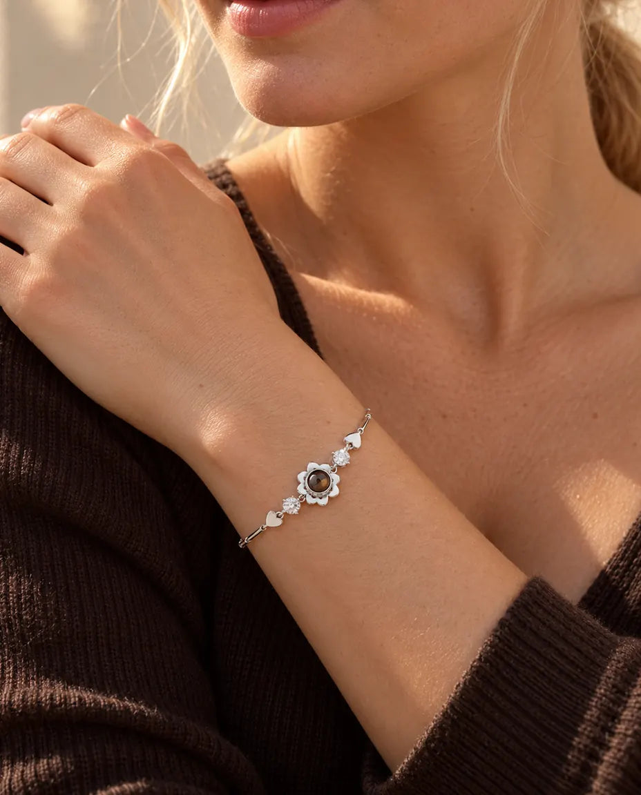 Mujer con la mano apoyada en el hombro y la pulsera plateada de trébol con foto dentro