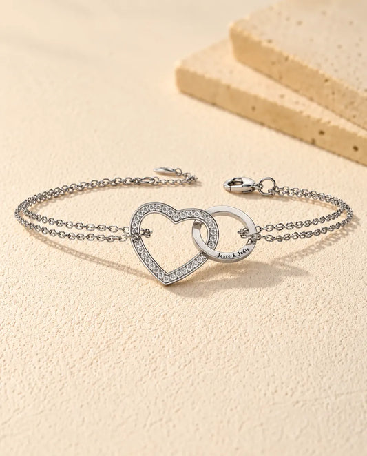 Pulsera grabada con corazón y aro entrelazados - vista frontal en plata