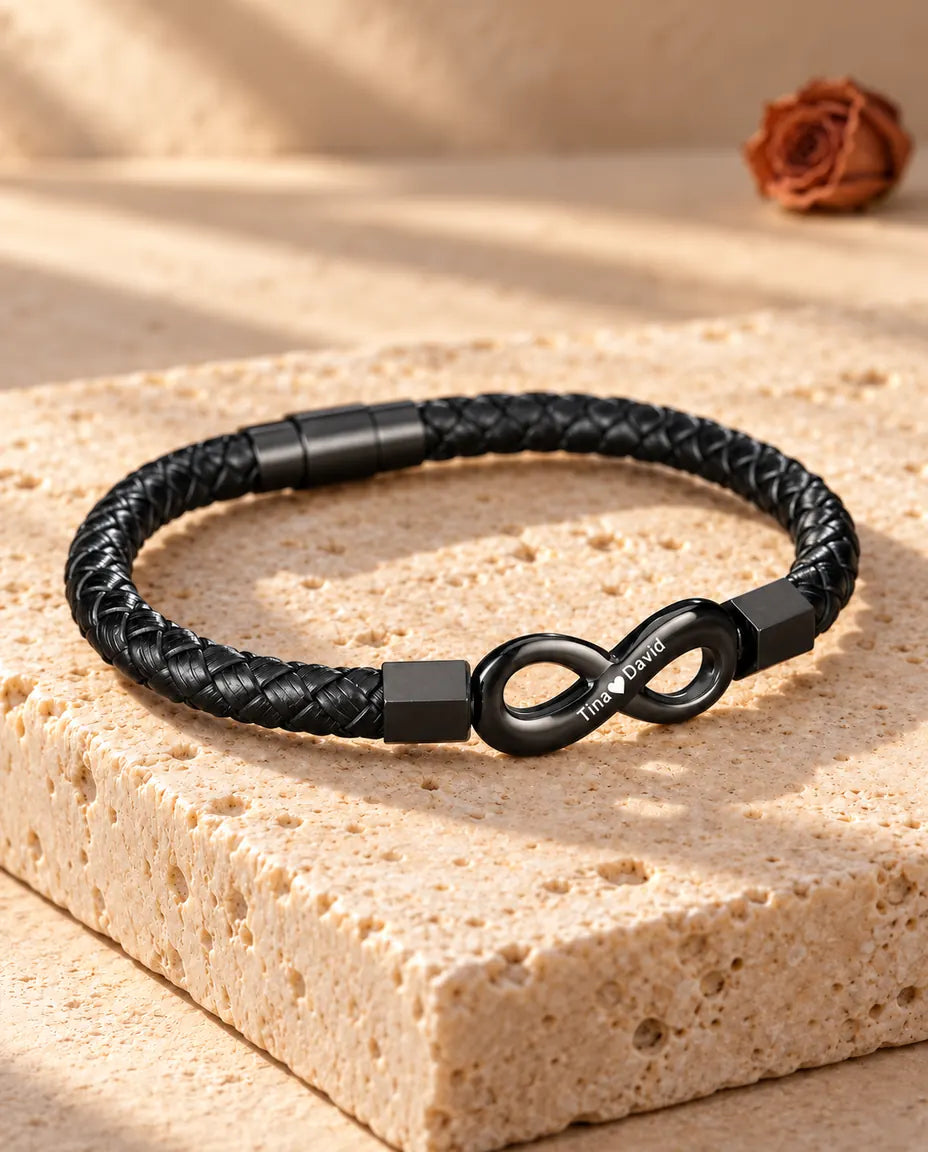 Vista de tres cuartos de la pulsera infinito grabada para hombre con cierre magnético cilíndrico sobre travertino