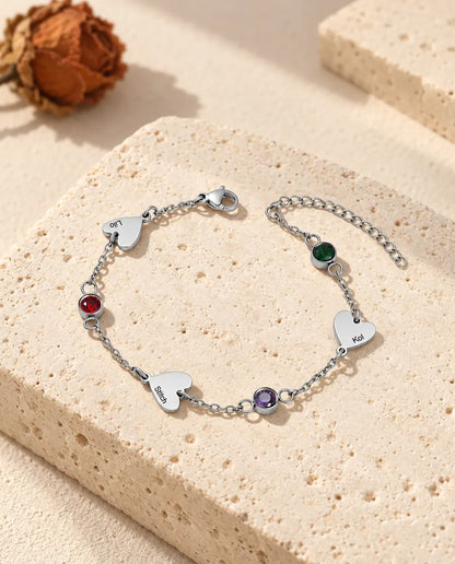 Pulsera de nombres de acero inoxidable con tres corazones grabados y tres piedras de nacimiento