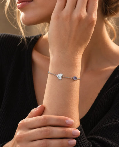 Mujer que lleva la pulsera de corazones con nombre y piedra de nacimiento, con un solo corazón grabado
