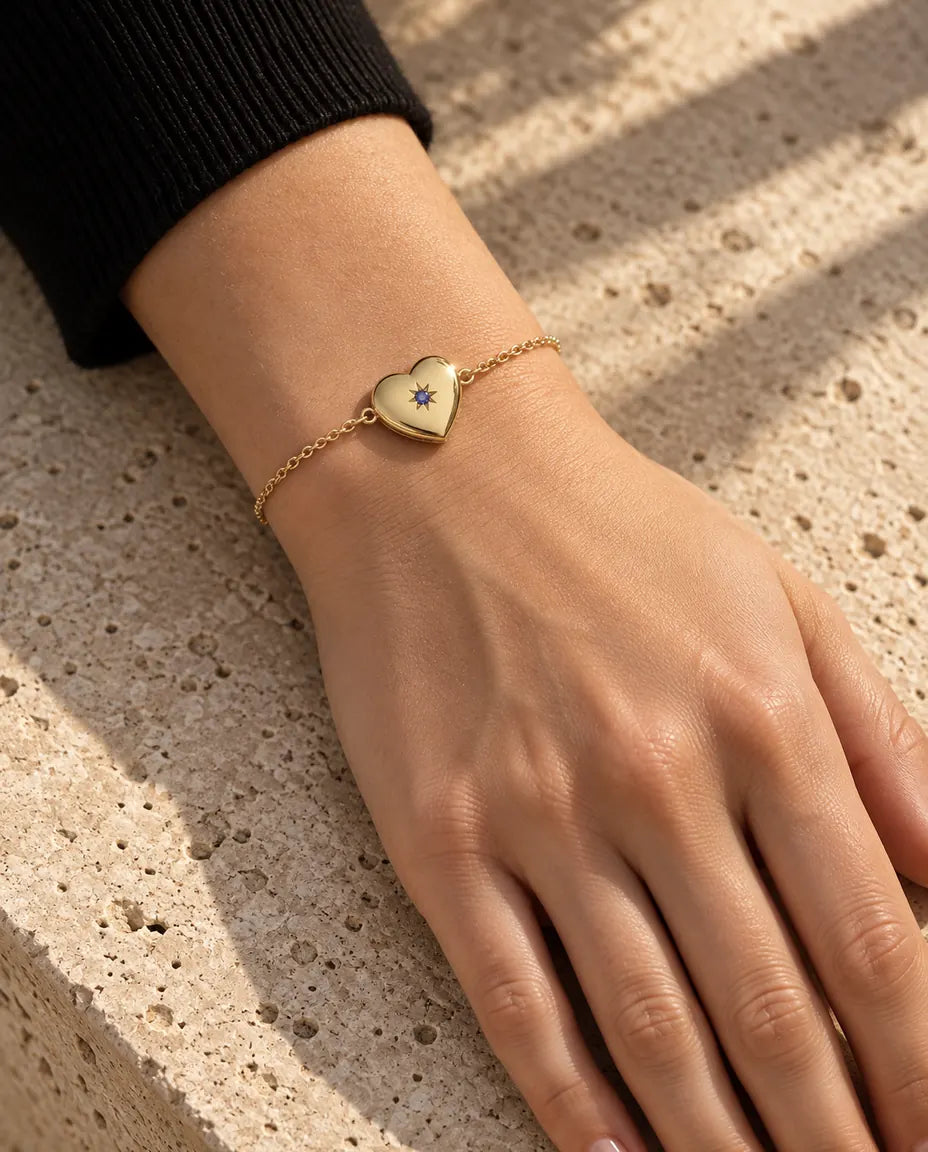 Vista cercana de la pulsera relicario de corazón en la muñeca