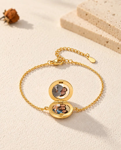 Pulsera relicario redondo abierta con dos fotos, en ángulo bajo