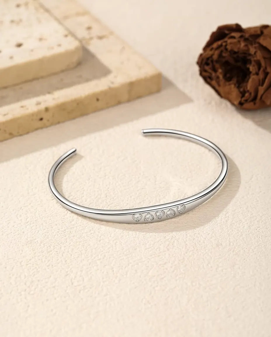 Pulsera Rígida de Moissanita en Plata 925 - tumbada sobre una superficie clara con textura