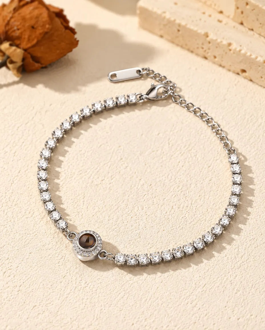 Pulsera tenis con foto dentro personalizada en plateado con charm de halo, sobre yeso crema