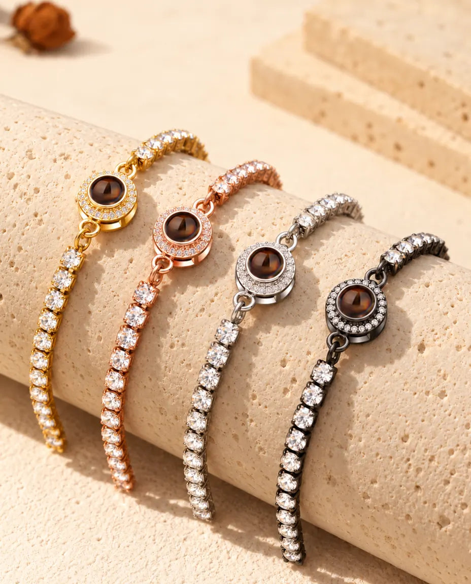 Cuatro pulseras tenis con foto dentro, una de cada color, colgando sobre un bloque de travertino