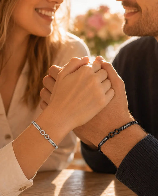 Pulseras de Pareja con 2 Nombres Grabados - Pulseras Infinito a Juego Plateada y Negra - llevadas por una pareja de la mano